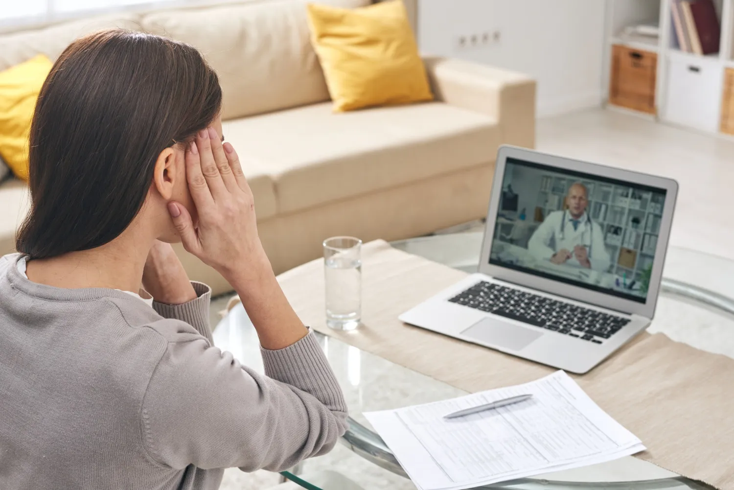 Woman consulting a doctor through a laptop at home, illustrating telehealth services in Jacksonville.