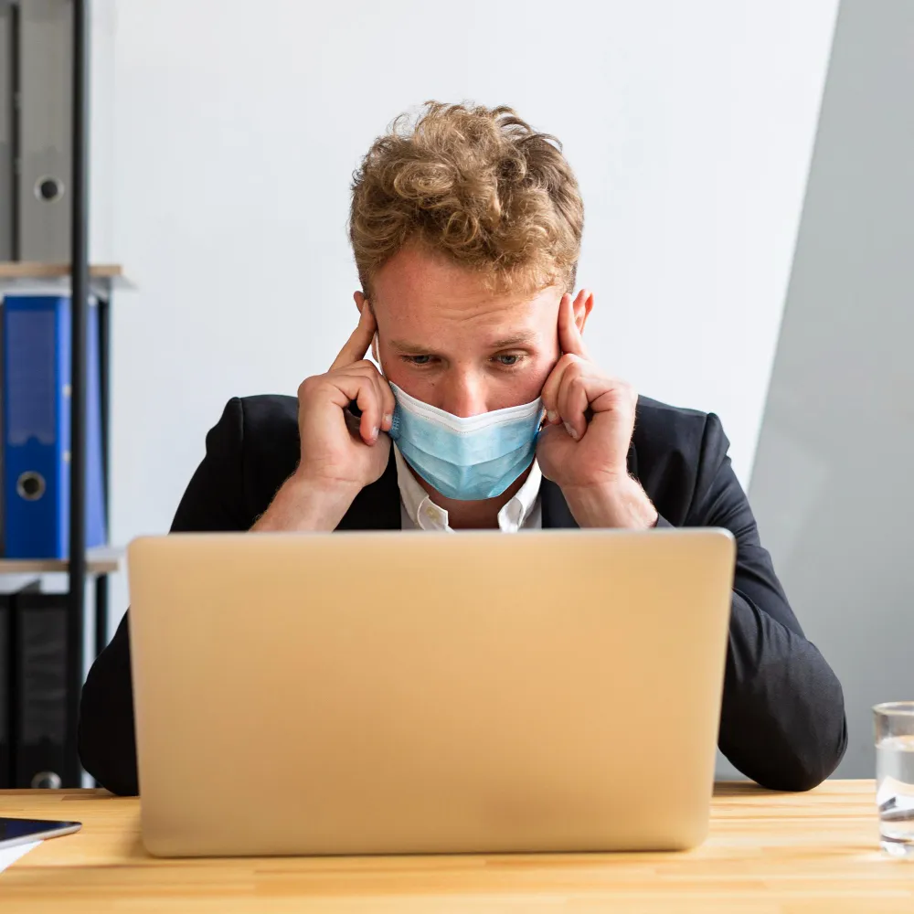 Man experiencing stress while using a laptop, highlighting concerns about accessing telemedicine solutions in Jacksonville.