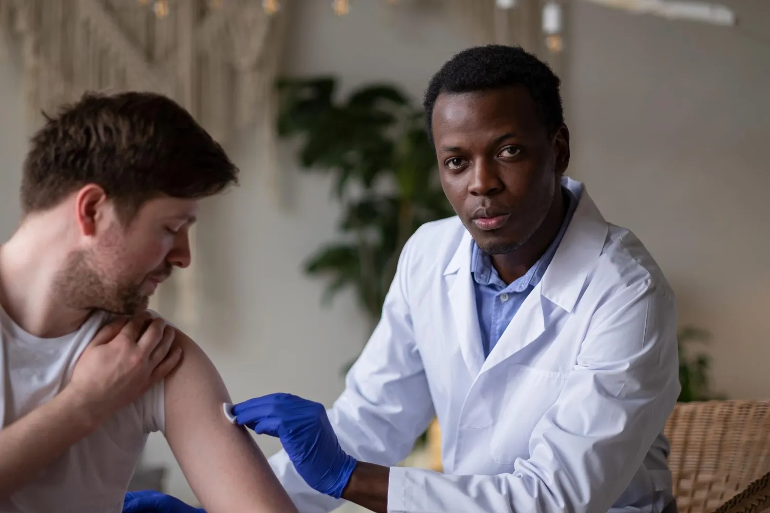 Healthcare professional examining a patient’s shoulder for wound care treatment.