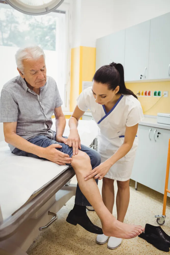 Healthcare provider examining an older patient’s leg as part of wound care in Jacksonville, FL.