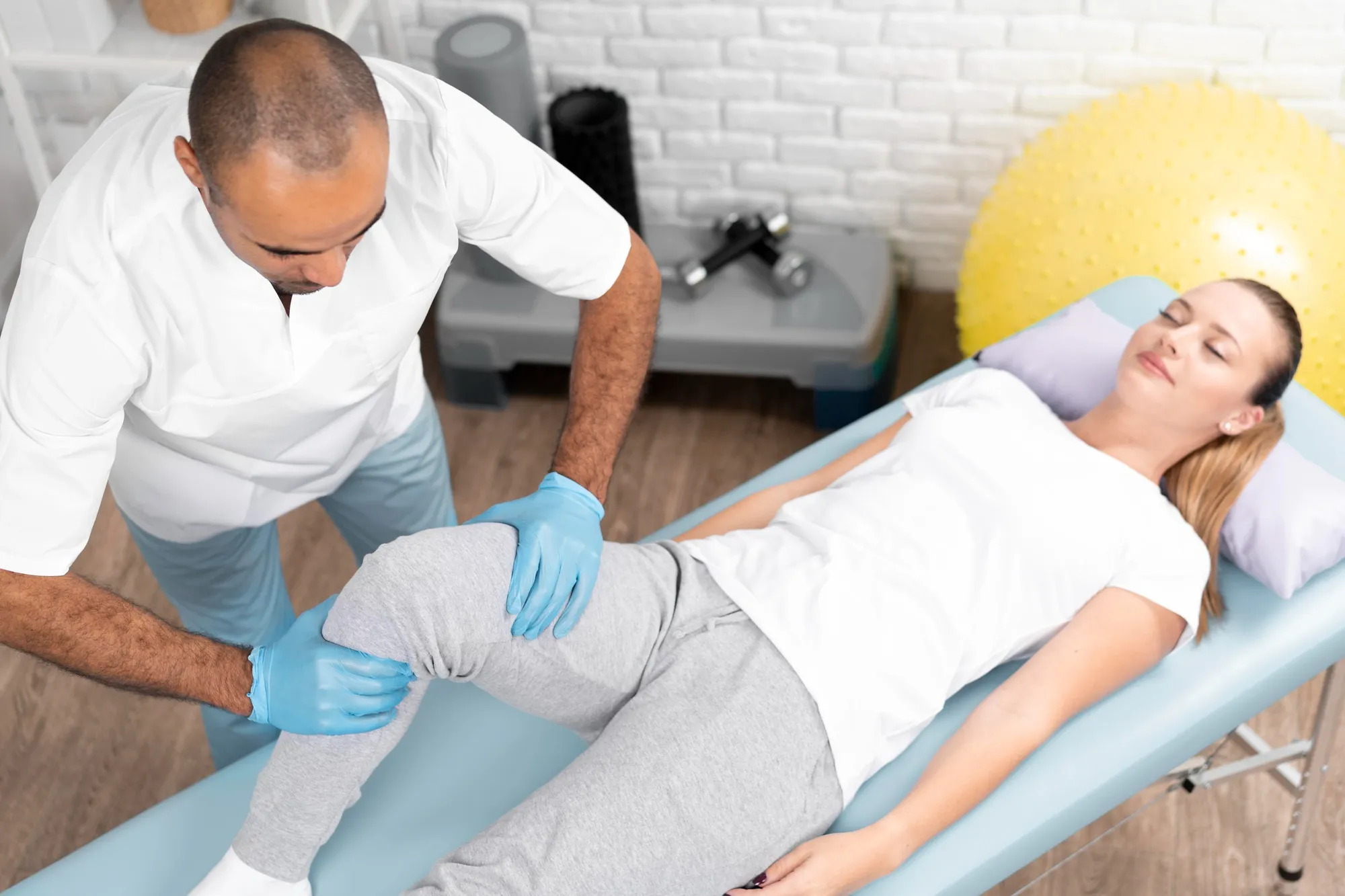 Physical therapist helping a patient with leg rehabilitation for Injury Recovery Services.