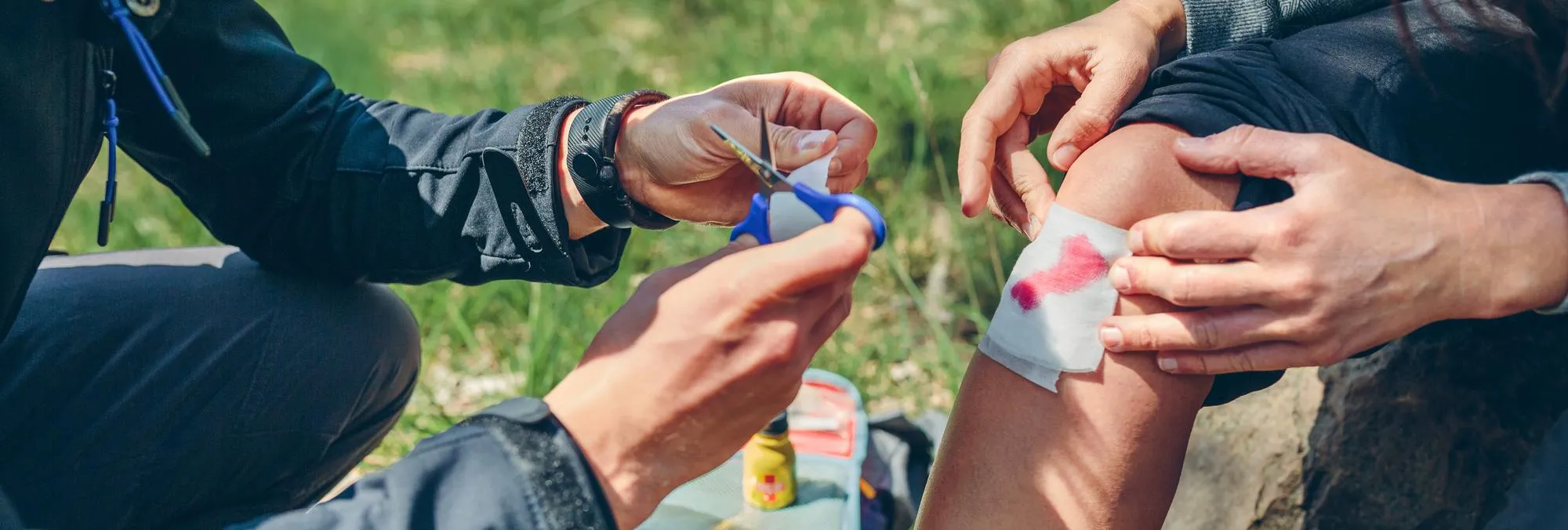 First aid treatment being provided for a knee wound, illustrating Wound Care Treatments.