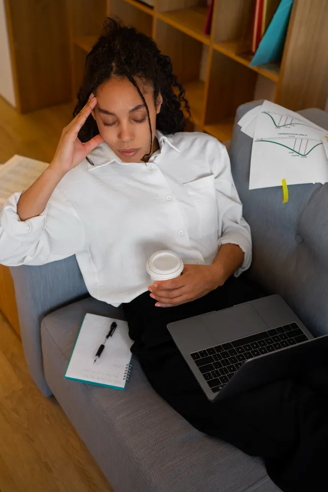 Woman experiencing stress and fatigue while working from home, highlighting the need for anxiety or depression treatment in Jacksonville.