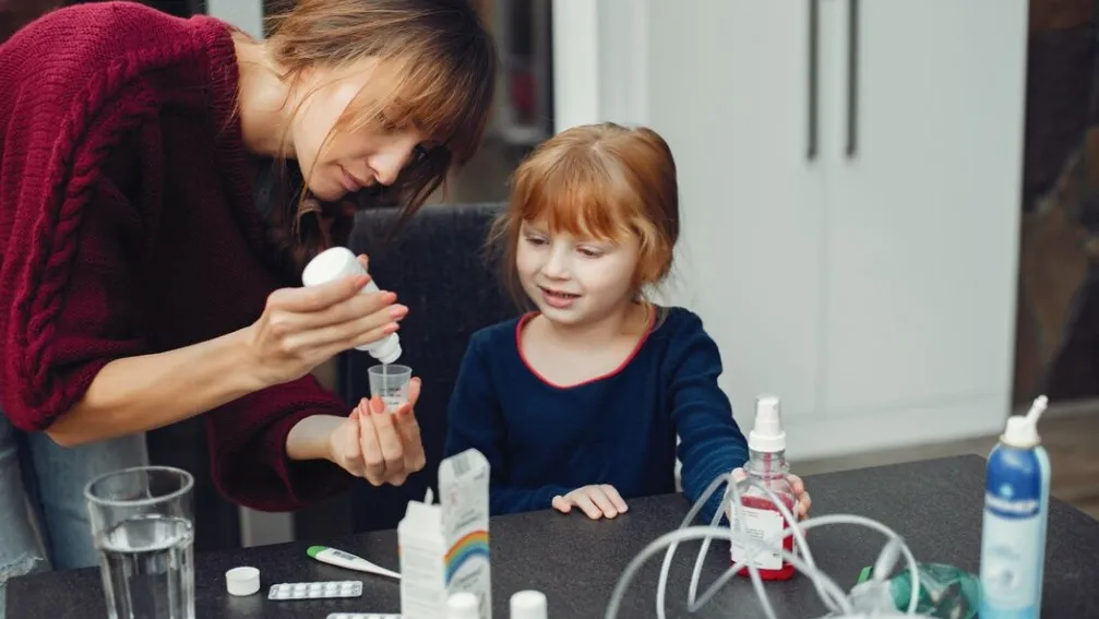 Parent measuring liquid medicine for a child with support from pharmacy sync services at a pharmacy in Jacksonville FL to ensure accurate dosing and timely refills.