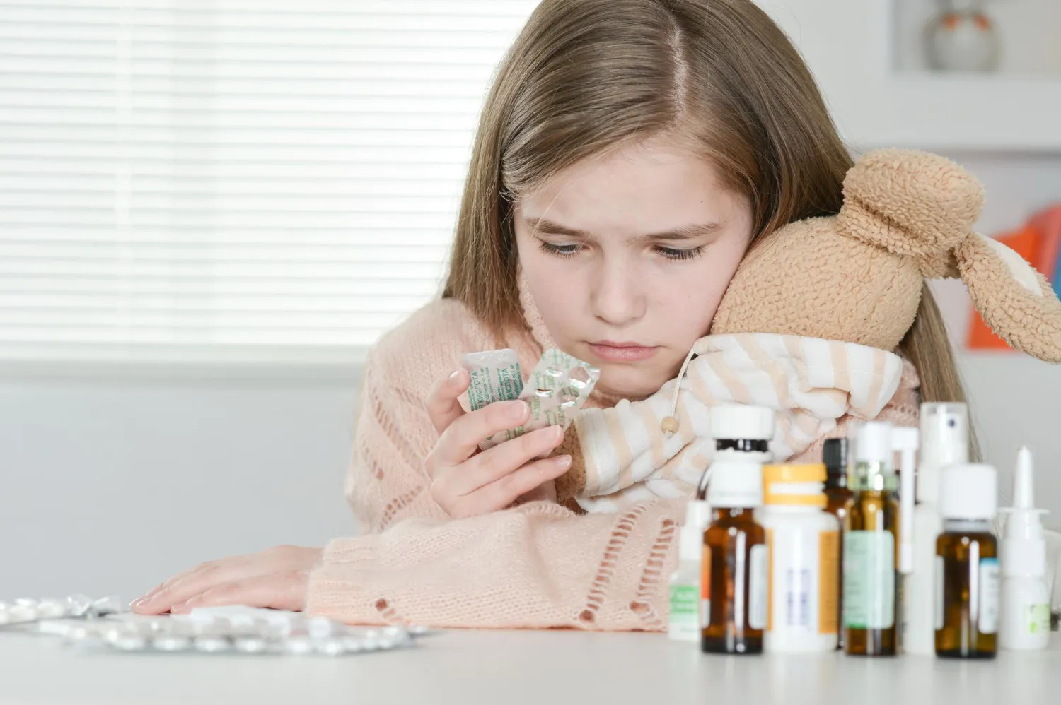 Child holding medication while receiving personalized treatment from a pediatric compounding pharmacy offering flavored pediatric compounding for improved medication adherence.