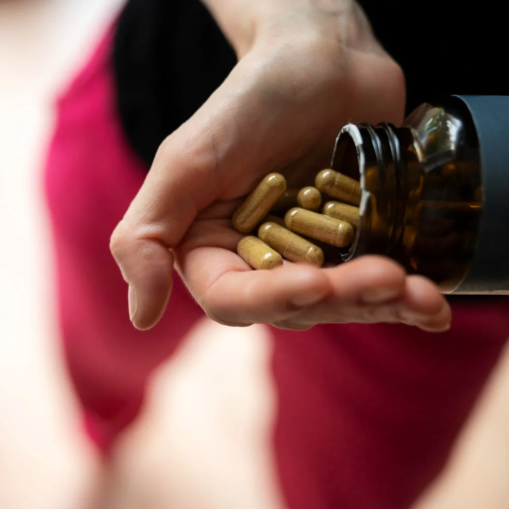 Close-up of compounded medication capsules being dispensed into a patient's hand, illustrating weight loss compounding pharmacy services and customized prescription medications.