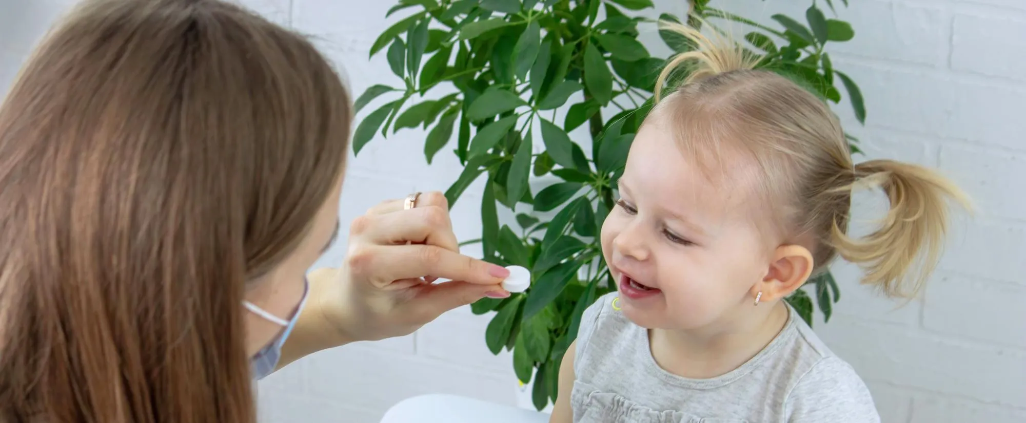 Healthcare provider giving child-friendly compounded medicine at pediatric compounding pharmacy clinic