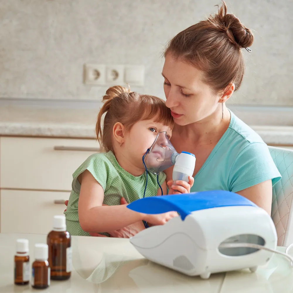 Mother helping child use nebulizer machine for respiratory treatment at pediatric compounding pharmacy