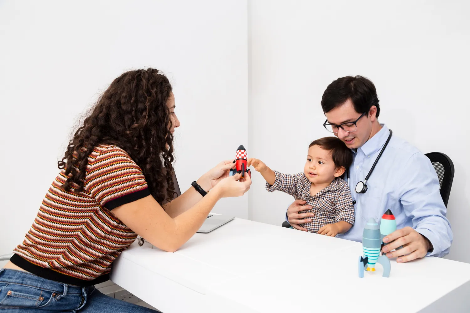 Pediatric compounding pharmacy consultation with a healthcare provider, parent, and child discussing personalized medication options and treatment needs
