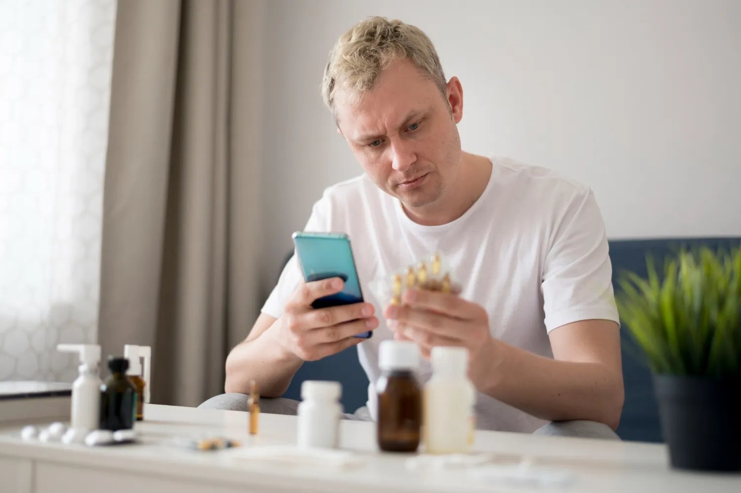 Man reviewing prescription medications on his phone before consulting erectile dysfunction doctors in Jacksonville about customized ED treatment options and compounded medications.