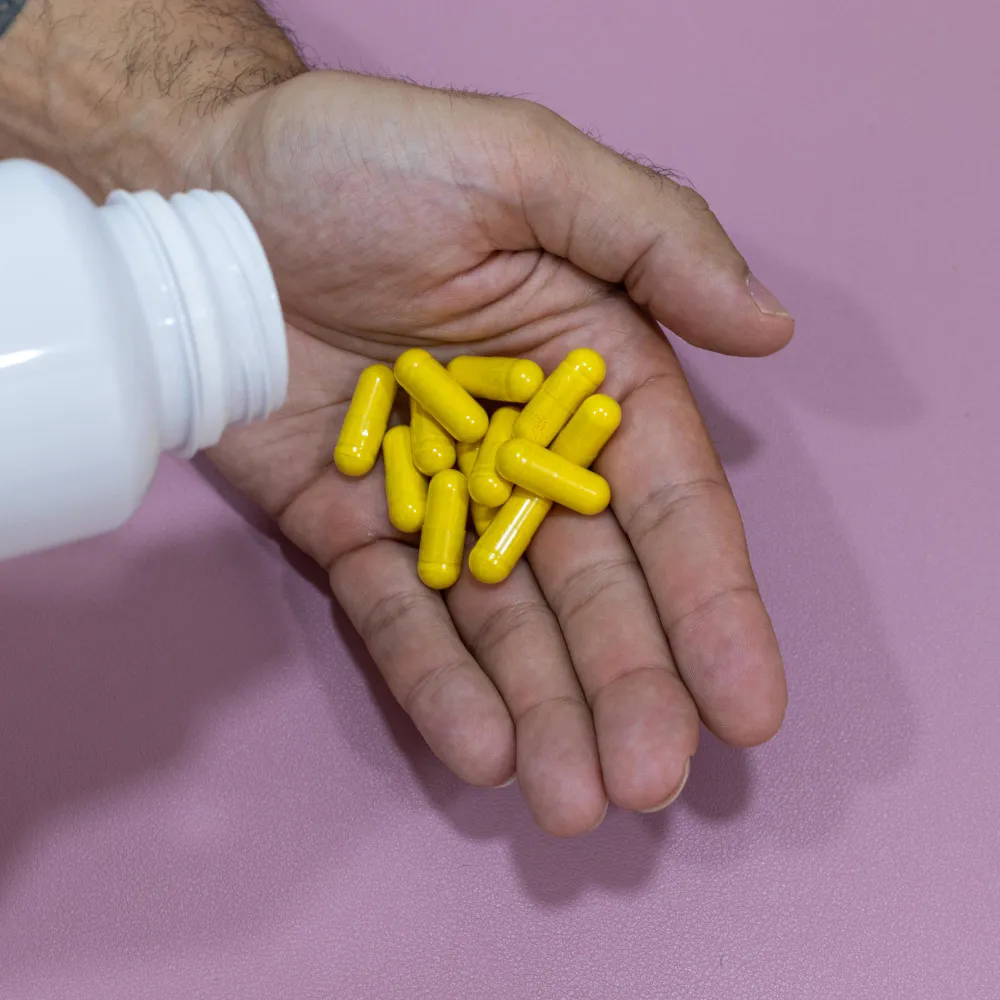 Close-up of compounded medication capsules in a patient's hand, representing services provided by an ED compounding pharmacy for personalized erectile dysfunction treatment.