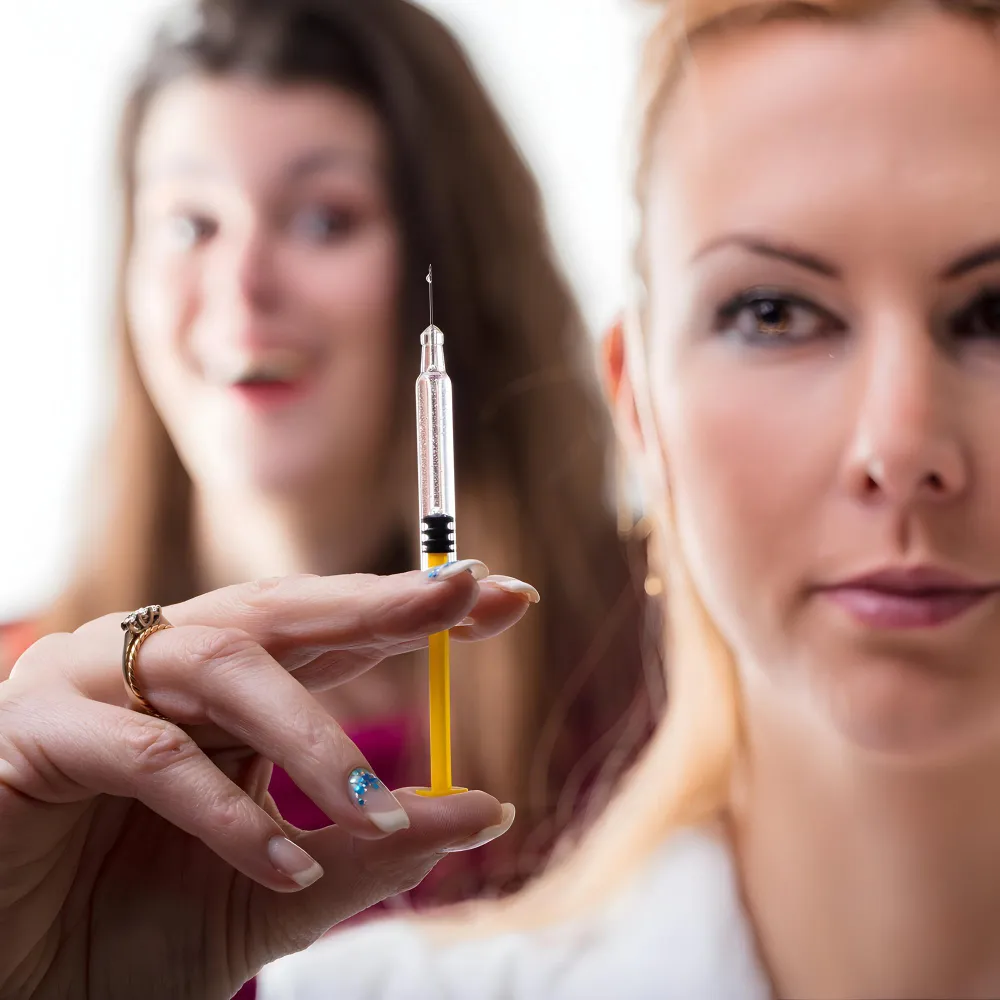 Woman holding a syringe while preparing for Hormone Replacement Therapy Jacksonville.