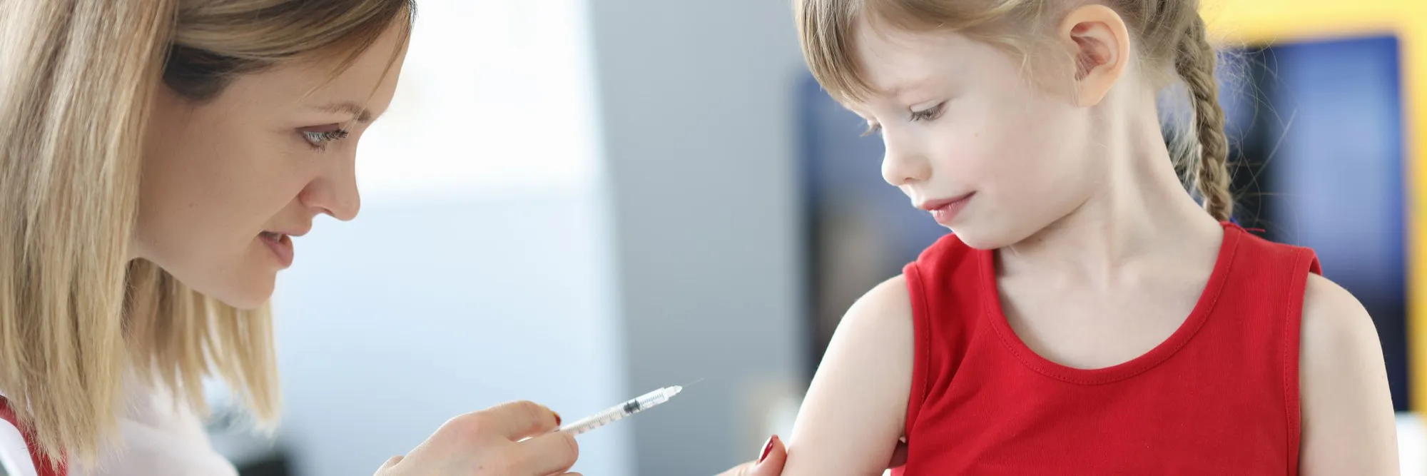 Healthcare professional administering medication to a child, illustrating care provided by a pediatric compounding pharmacy.